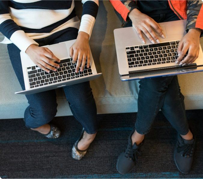 Two people with laptops on their laps
